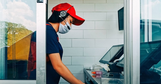 Cashier at fast food drive thru window