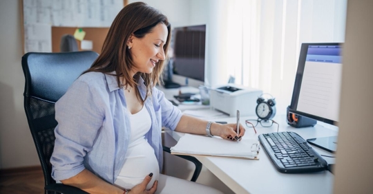 Pregnant woman at computer